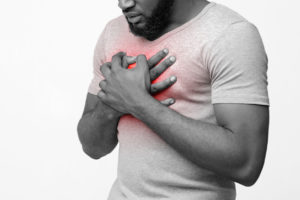 Cropped of afro man suffering from acid reflux or heartburn, symptomatic indigestion or gastritis disease, white background