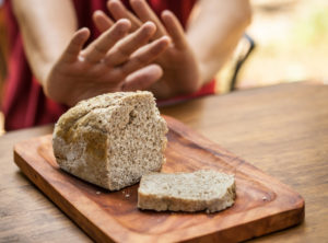 Male hands refusing or rejecting a sliced loaf of bread due to Celiac Disease