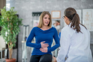 Woman With digestive issue at doctor appoinment